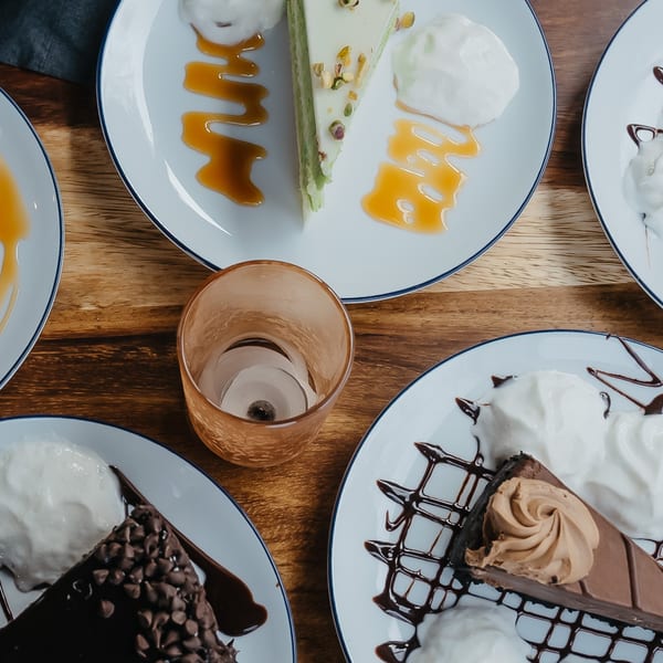 Assortment of Mexican desserts, including pistachio, chocolate chip, and mocha cakes with whipped cream.