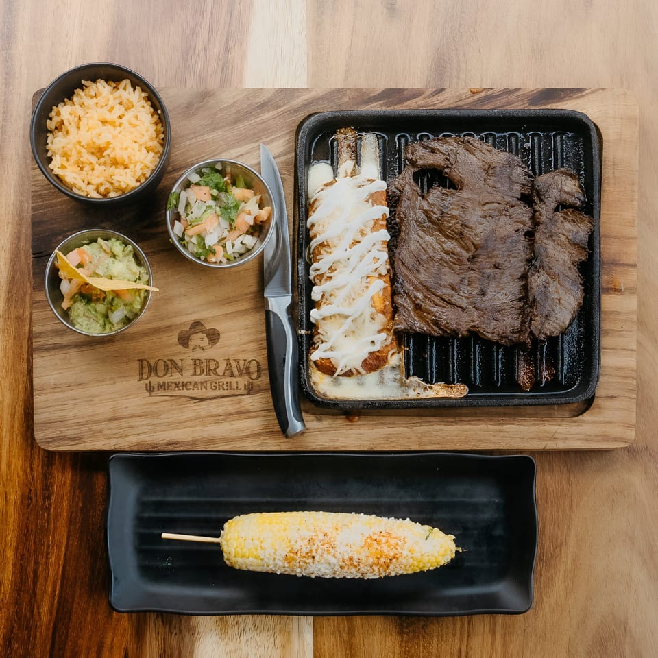 Don Bravo Mexican Grill's carne asada, enchiladas, rice, guacamole, pico de gallo, and elote.